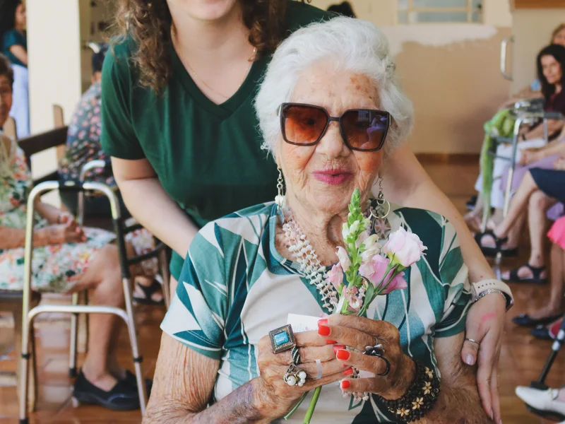 Momento especial com óculos de sol e flores nas mãos