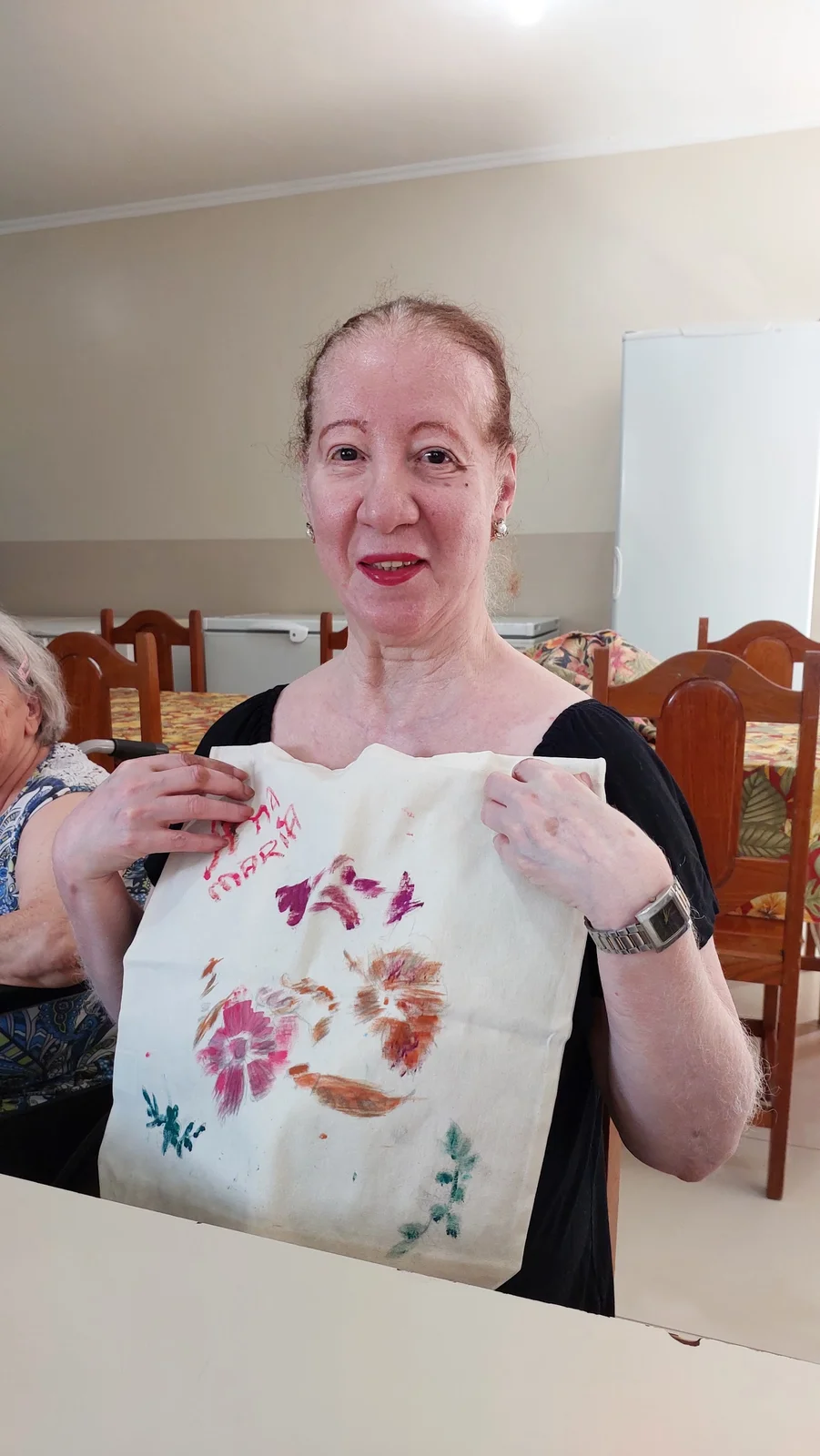 Dona Maria com ecobag pintada em oficina de terapia ocupacional